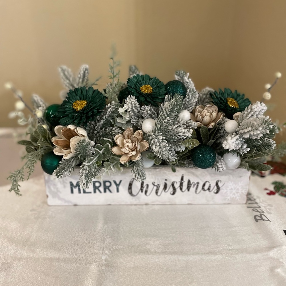 Centerpiece with snowy greenery, neutral sola flowers with deep green baubles